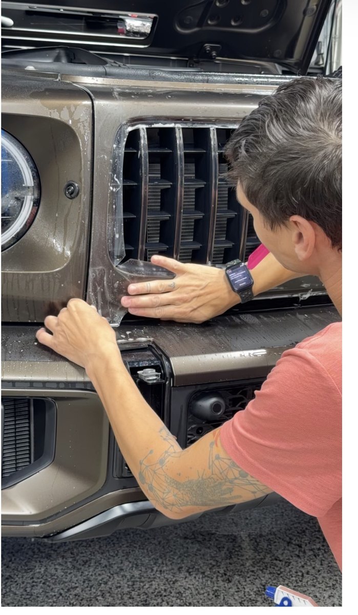 Close-up of film being worked around a chrome grille surround