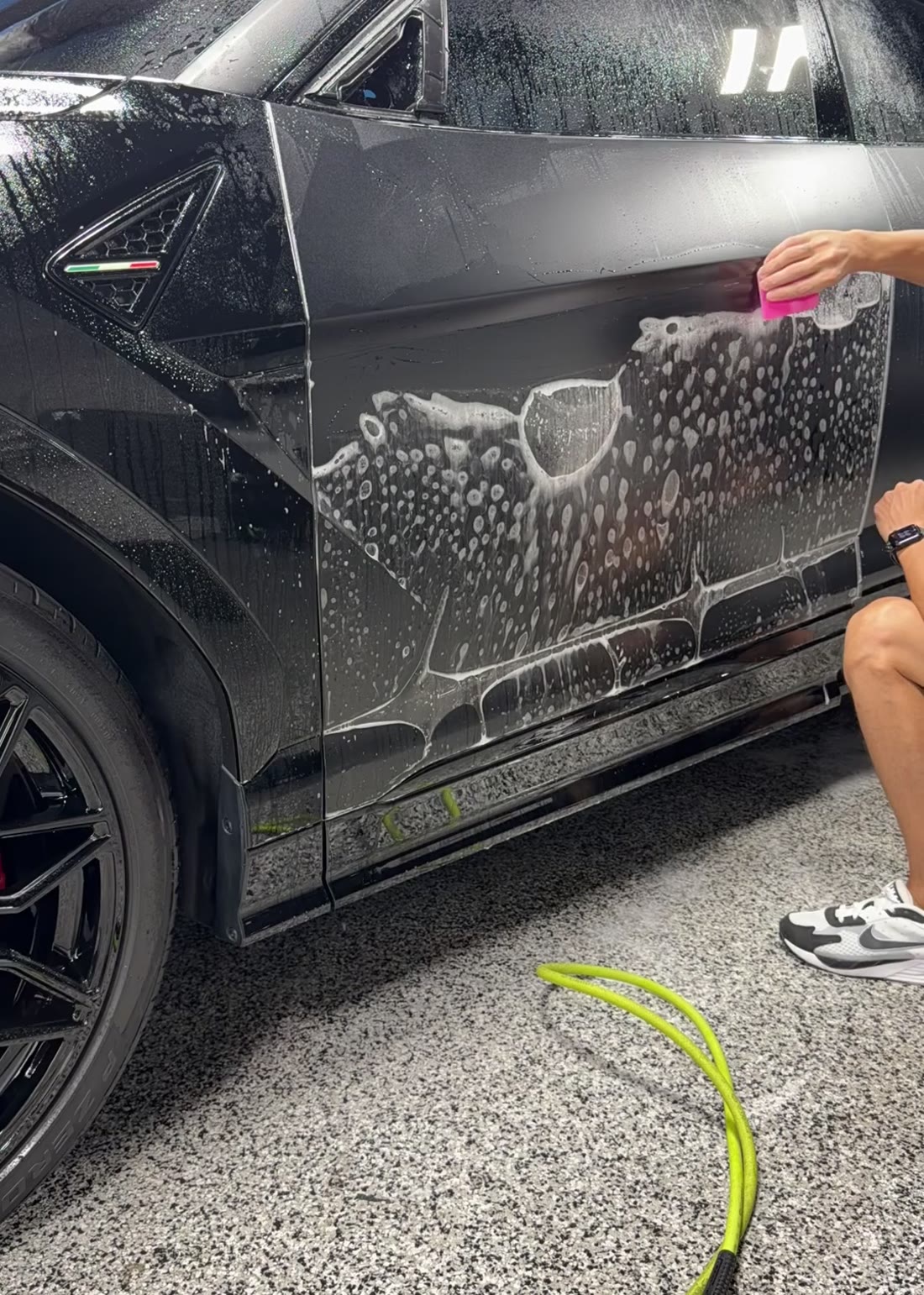 Squeegee work along the door and rocker panel during a full-body film install